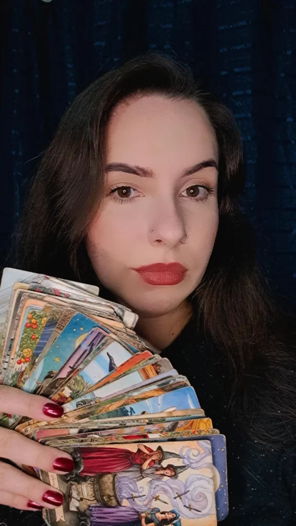 Imagem da Sacerdotisa Viviane segurando um baralho de tarot.